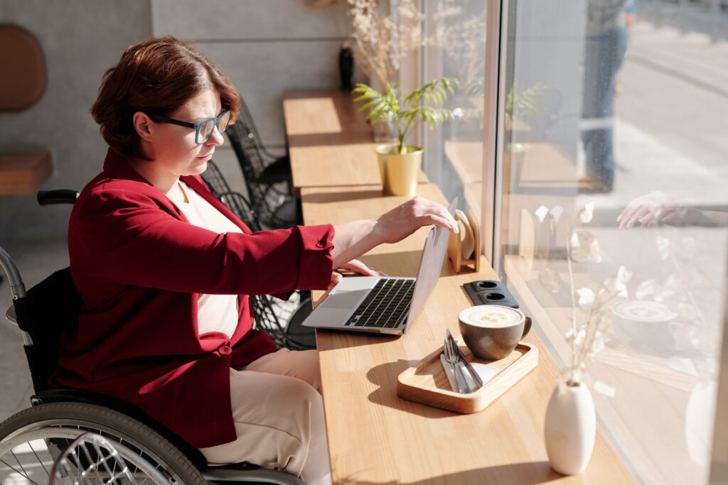 A woman in a wheelchair looking at her laptop